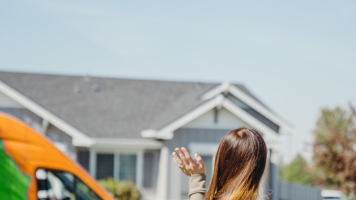 women in front yard waving at wickstrom truck